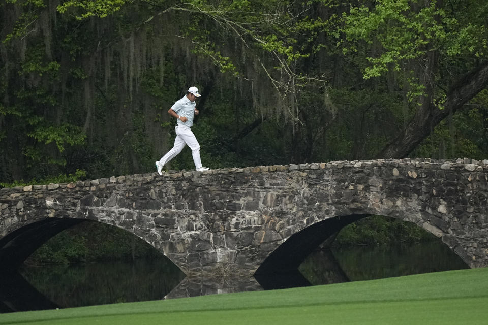 Hideki Matsuyama, of Japan, runs across the Nelson Bridge on the 13th hole during the third round of the Masters golf tournament on Saturday, April 10, 2021, in Augusta, Ga. (AP Photo/David J. Phillip)