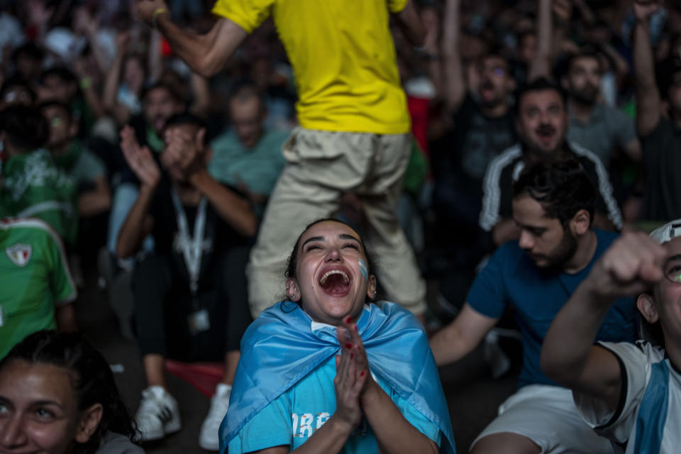 A fan of Argentina reacts after Argentina's Lionel Messi scores his side's opening goal against Mexico as she watch on a giant screen during a World Cup group C soccer match between Argentina and Mexico at the FIFA Fan Festival in Doha, Qatar, Saturday, Nov. 26, 2022. (AP Photo/Manu Fernandez)