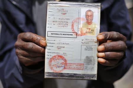 An African migrant shows his ID at a detention centre in Zawiya, northern Libya May 27, 2014. REUTERS/Ahmed Jadallah