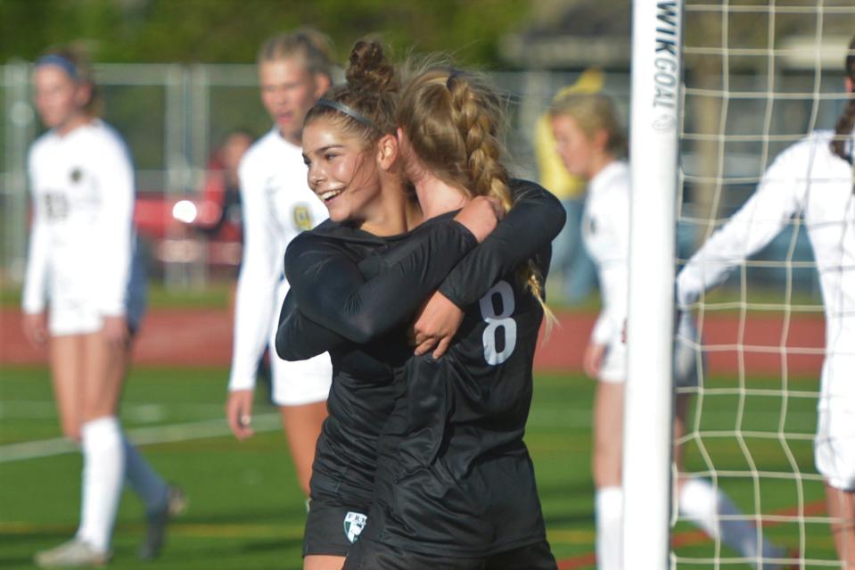 Fossil Ridge soccer player Abby Ballek, left, is hugged by teammate Liv Redmon after Ballek scored the first goal during a Class 5A second-round playoff game against Rock Canyon on May 12, 2023.
