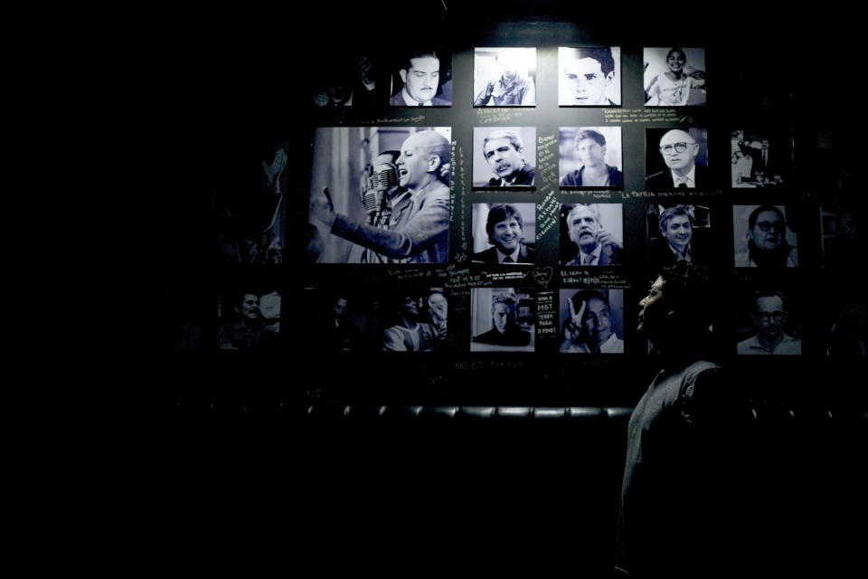 Employee Diego Arias poses next to a wall adorned with historical images featuring well-known Peronists including Argentine former first lady María Eva Duarte de Perón, better known as Eva Perón, or Evita, at the Peron Peron restaurant, in the San Telmo neighborhood of Buenos Aires, Argentina, Friday, Feb. 9, 2024. (AP Photo/Natacha Pisarenko)