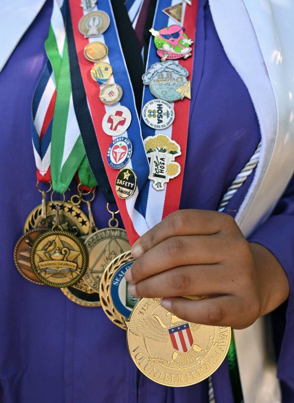 Elizabeth Gonzales-Cortes, de 18 años, muestra la colección de medallas que ganó a lo largo de sus años escolares. Gonzales-Cortes se gradúa en Madera South High School e irá a UC Irvine, donde estudiará biología y pre-medicina. Fotografía del viernes 17 de mayo de 2024 en las afueras de Madera.