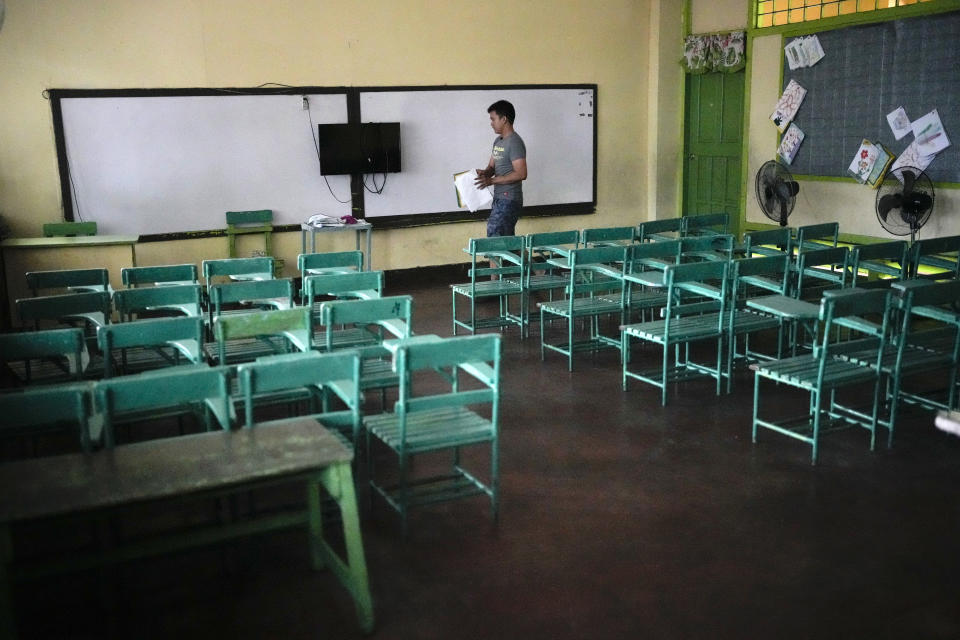 A teacher arranges papers at an empty classroom at the Justo Lukban Elementary School in Manila, Philippines on Monday, April 29, 2024. Millions of students in all public schools across the Philippines were ordered to stay home Monday after authorities cancelled in-person classes for two days as an emergency step due to the scorching heat and a public transport strike. (AP Photo/Aaron Favila)