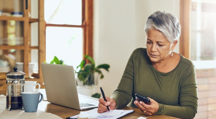 En pensionist beregner hendes krævede minimumsfordeling (RMD). IRS har opdateret sin Uniform Lifetime Table, hvilket reducerer størrelsen af ​​RMD'er i 2022.