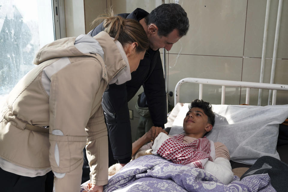 In this photo released by the official Syrian state news agency SANA, Syrian President Bashar Assad, center, and his wife Asma visit a wounded survivor of devastating earthquake, at a hospital in Aleppo province, Syria, Friday, Feb. 10, 2023. Rescuers pulled several people alive from the shattered remnants of buildings on Friday, some who survived more than 100 hours trapped under crushed concrete in the bitter cold after a catastrophic earthquake slammed Turkey and Syria. (SANA via AP)