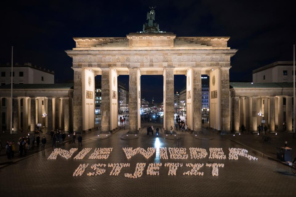 A sign "Never again is now" is written by candles in front of the Brandenburg Gate during a light campaign by Fridays for Future against right-wing extremism in Berlin, Germany, Friday, Jan. 26, 2024. The International Holocaust Remembrance Day marking the anniversary of the liberation of the Nazi death camp Auschwitz - Birkenau on Jan. 27, 1945.