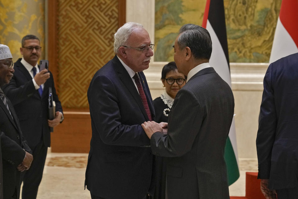 Chinese Foreign Minister Wang Yi, right, shakes hands with Palestine Foreign Minister Riyad al-Maliki as he meets with his five Arab and Islamic counterparts at the Diaoyutai state guesthouse in Beijing, Monday, Nov. 20, 2023. China's foreign minister welcomed five Arab and Islamic counterparts to Beijing on Monday, saying his country would work with "our brothers and sisters" in the Arab and Islamic world to try to end the fighting in Gaza as soon as possible. (AP Photo/Andy Wong)