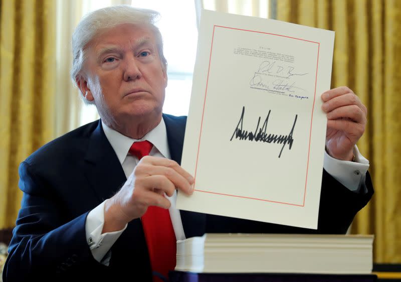 FILE PHOTO: U.S. President Trump displays signature after signing tax bill into law at the White House in Washington