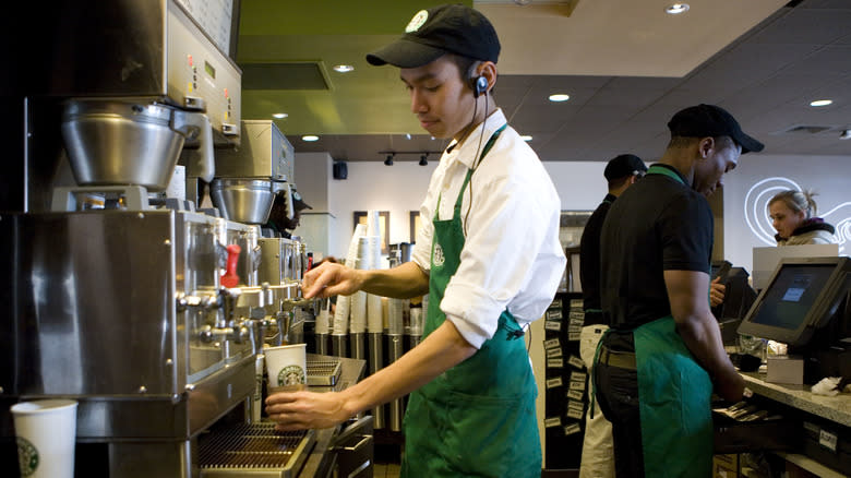 starbucks worker pouring black coffee
