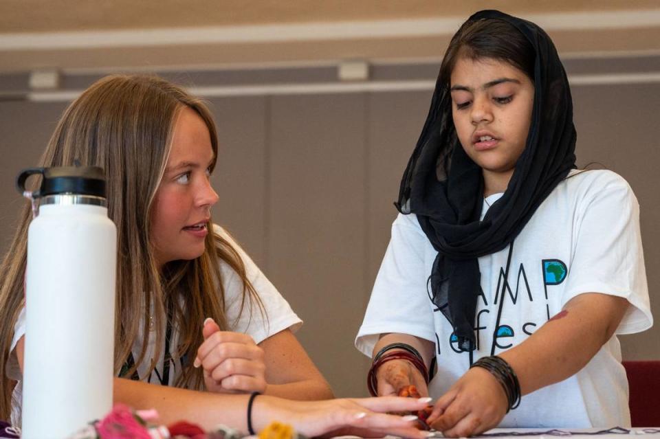 Camp counselor Liberty Daily, 17, helps Zenat Rahmani, 10, braid a friendship bracelet at Camp Nefesh in Sacramento on Wednesday.