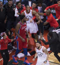Toronto Raptors forward Kawhi Leonard, center, reacts with teammates after making the game-winning shot as Philadelphia 76ers center Joel Embiid (21) walks away at the end of an NBA Eastern Conference semifinal basketball game, in Toronto, Sunday, May 12, 2019. (Nathan Denette/The Canadian Press via AP)