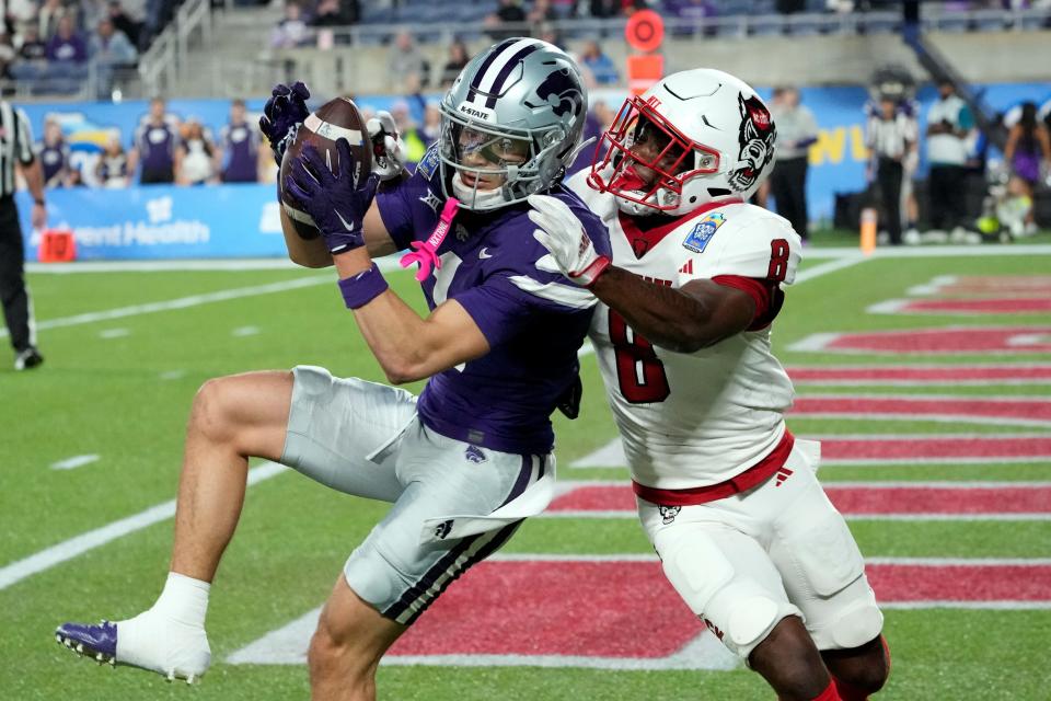 Kansas State wide receiver Jayce Brown (1) catches an 11-yard touchdown pass in front of North Carolina State's Robert Kennedy (8) in the fourth quarter of the Pop-Tarts Bowl on Thursday at Camping World Stadium.