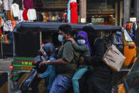 An Indian family wearing face masks as a precaution against the coronavirus rides on a scooter through a street in Hyderabad, India, Wednesday, Dec. 9, 2020. India has more than 9 million cases of coronavirus, second behind the United States. (AP Photo/Mahesh Kumar A.)