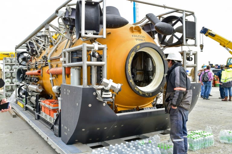 A worker stands next to a US Navy rescue capsule that can sink to a depth of 200 meters (655 feet) and rescue up to 16 trapped submarine sailors at a time