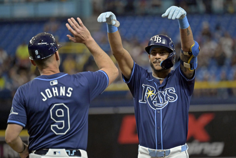Tampa Bay Rays first base coach Michael Johns (9) congratulates Jose Siri for an RBI single off Seattle Mariners starter Luis Castillo during the second inning of a baseball game Tuesday, June 25, 2024, in St. Petersburg, Fla. (AP Photo/Steve Nesius)