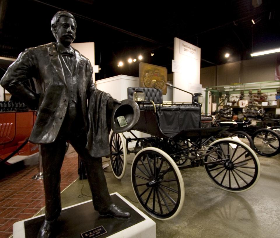 A statue of R.E. Olds along with classic vehicles made by Oldsmobile await visitors to the museum, located at 240 Museum Drive in Downtown Lansing.