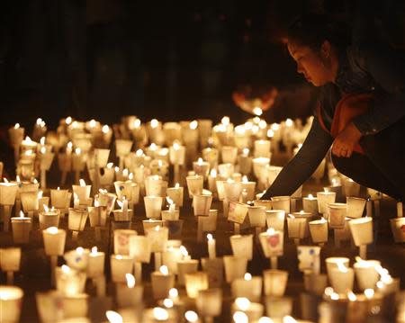 A woman attends a candlelight vigil in Ansan, to commemorate the victims of capsized passenger ship Sewol and to wish for the safe return of missing passengers, April 24, 2014. REUTERS/Kim Hong-Ji