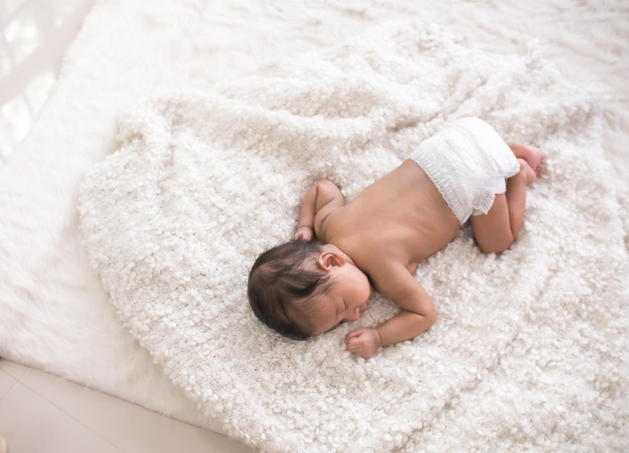 Sweet newborn baby sleeping on white bed