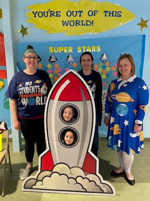 Nicole Merrigan, Carissa Ryan, and Kristy Croft were a few of the fabulous teachers who made Math and Literacy Night spectacular. They are shown here with two students in a cardboard cutout of a rocket ship.