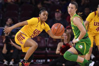 Southern California guard Desiree Caldwell left, and Oregon guard Sabrina Ionescu go after a loose ball during the first half of an NCAA college basketball game Sunday, Feb. 16, 2020, in Los Angeles. (AP Photo/Mark J. Terrill)