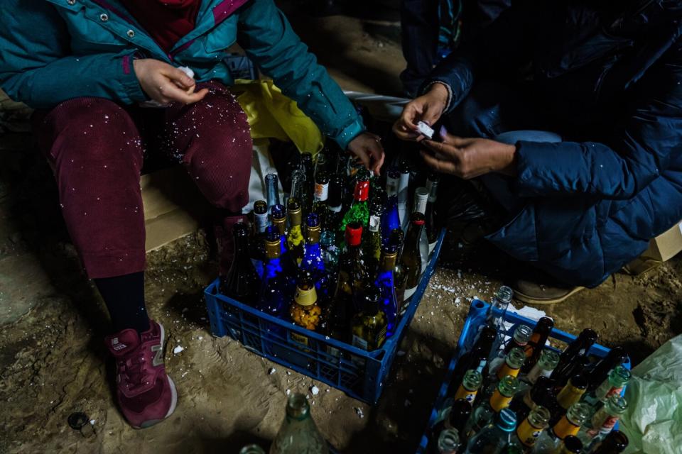 Volunteers from the Territorial Defense Units collect glass bottles to make Molotov cocktails