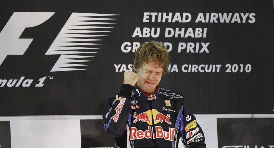 FILE - Red Bull driver Sebastian Vettel of Germany cries on the podium after becoming 2010 Formula One World champion and winning the Emirates Formula One Grand Prix at the Yas Marina racetrack, in Abu Dhabi, United Arab Emirates, Sunday, Nov.14, 2010. Four-time Formula One champion Sebastian Vettel says he will retire at the end of the season to spend more time with his family. The German driver won the F1 title from 2010-13 with the Red Bull team. His last race victory came with Ferrari in 2019. (AP Photo/Luca Bruno, File)