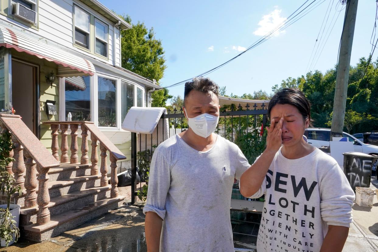 Danny Hong and his wife Wenqing Ou are emotional as they talk to reporters in front of their flooded home in the Flushing neighborhood of the Queens borough of New York, Thursday, Sept. 2, 2021, in New York.
