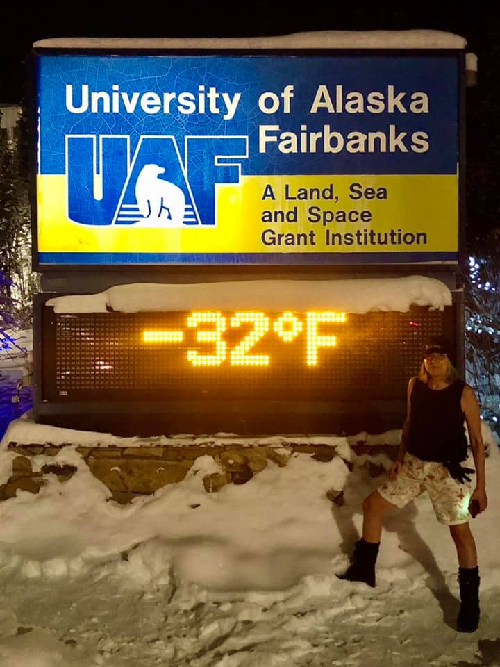 Deb Hickok poses in front of a temperature sign reading at -32° F at the University of Alaska Fairbanks. Students, locals and visitors snap these trophy shots for social media posts. Wearing a bathing suit or shorts adds to the dramatic effect.