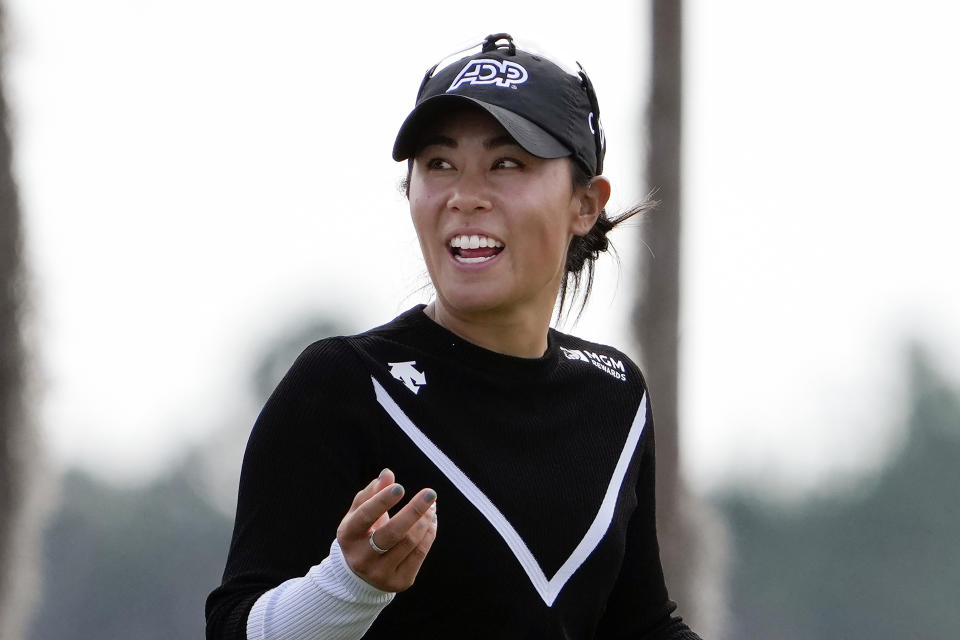 FILE - Danielle Kang shares a laugh with her caddie as she walks to the 18th green during the first round of the LPGA Hilton Grand Vacations Tournament of Champions, Jan. 19, 2023, in Orlando, Fla. Kang avoided distractions in a rain-soaked round and shot a 9-under 63 on Friday, March 3, 2023 for a one-shot lead after the second round of the Women's World Championship in Singapore. (AP Photo/John Raoux, File)