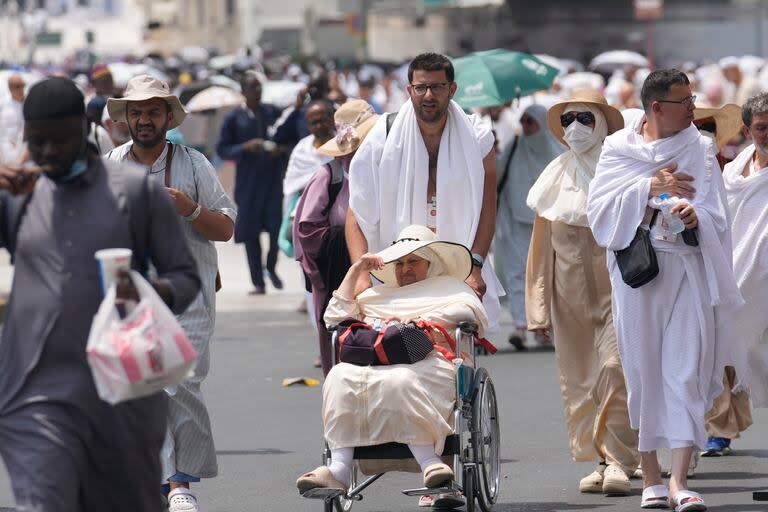 Peregrinos salen después de orar, fuera en la Gran Mezquita, durante la peregrinación anual de hach en La Meca, Arabia Saudí, el jueves 13 de junio de 2024. (AP Foto/Rafiq Maqbool)
