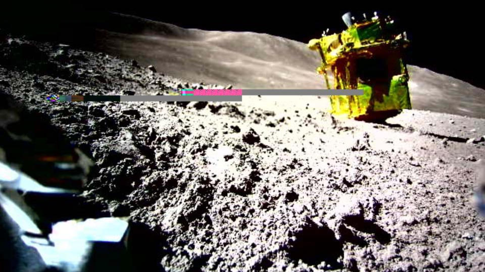 a golden cube on the surface of the moon amid gray dust and rocks