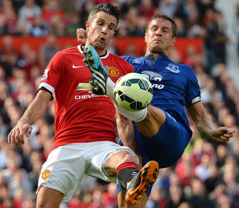 Everton's Phil Jagielka (R) challenges Manchester United's Robin van Persie during their English Premier League match at Old Trafford in Manchester, on October 5, 2014