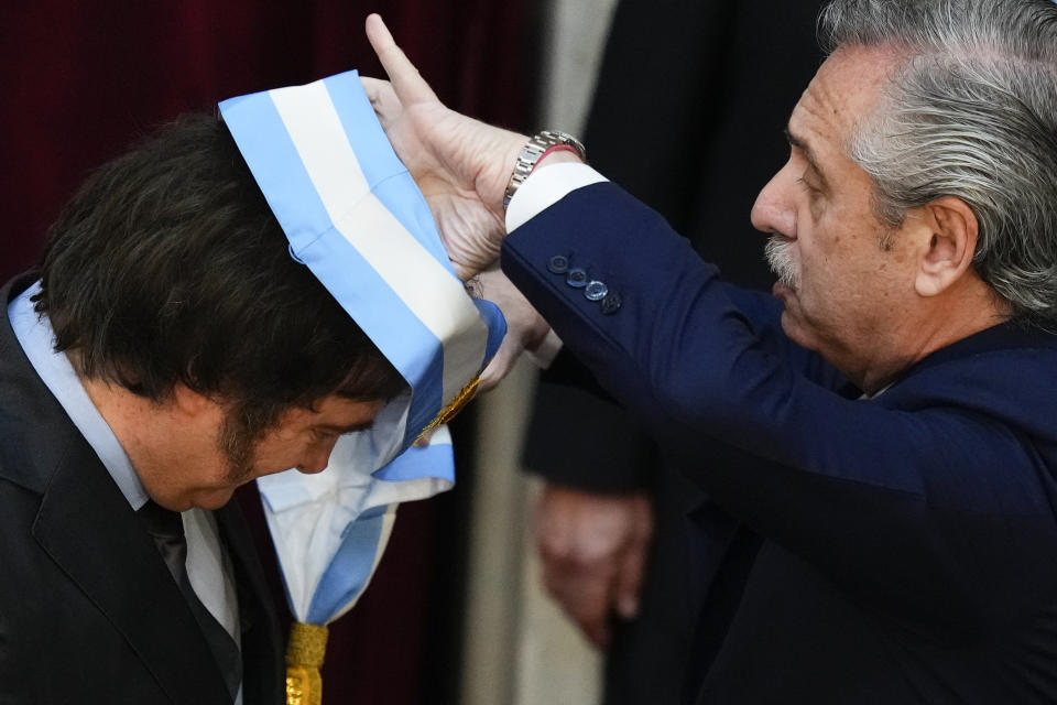Argentina's incoming President Javier Milei receives the presidential sash from outgoing President Alberto Fernandez at the Congress in Buenos Aires, Argentina, Sunday, Dec. 10, 2023. (AP Photo/Natacha Pisarenko)