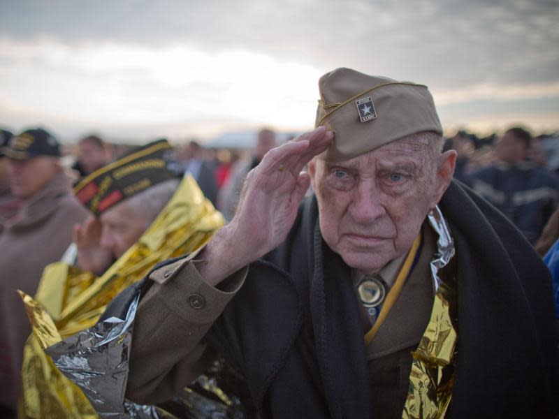 Weltkriegsveteran Raymond Sylvester aus den USA während einer Gedenkveranstaltung am Utah Beach in der Normandie in Frankreich, eingehüllt in eine Wärmedecke. Foto: Michael Kappeler