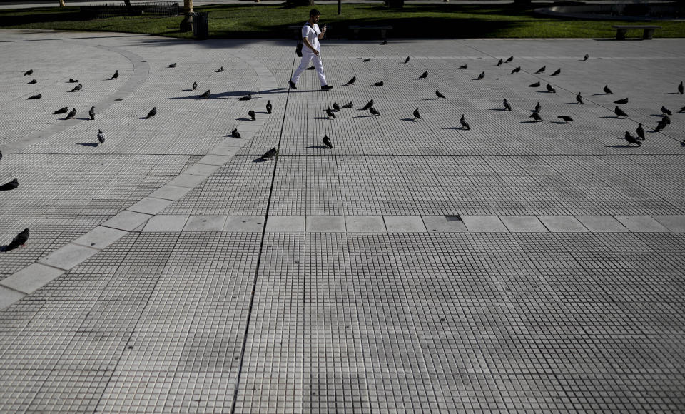 Un médico cruza una Plaza de Mayo vacía en Buenos Aires, Argentina, el viernes 20 de marzo de 2020. El gobierno de Argentina impuso una cuarentena nacional obligatoria para contener la propagación del coronavirus. (AP Foto / Natacha Pisarenko)