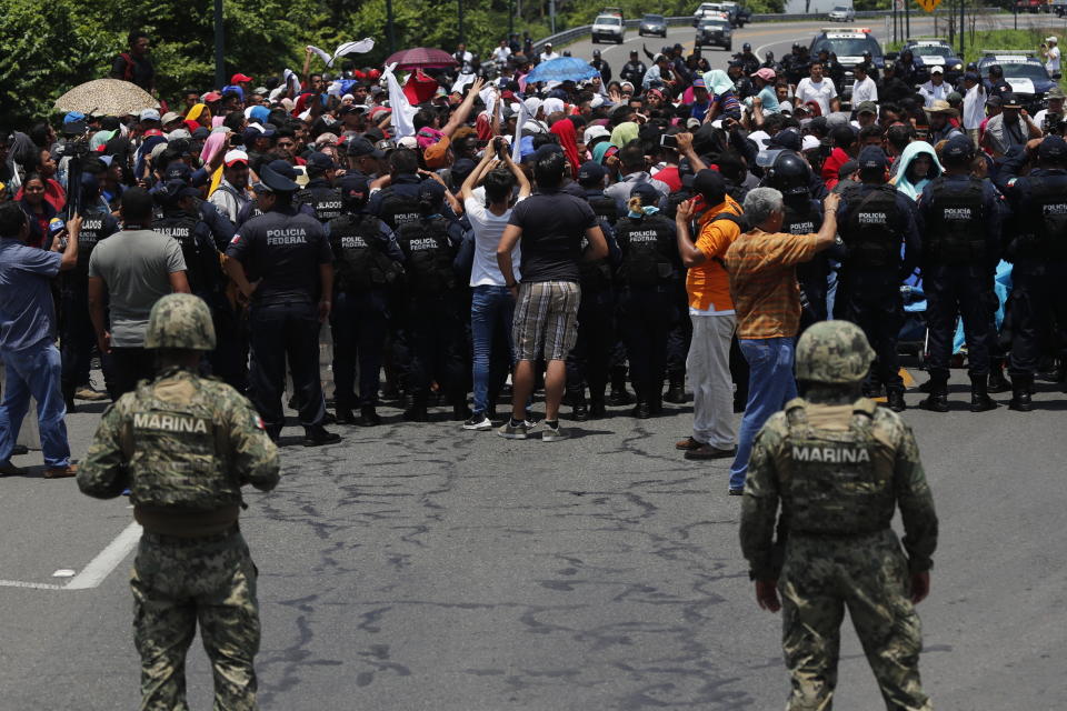 FILE - In this June 5, 2019 file photo, Mexican authorities stop a migrant caravan that had earlier crossed the Mexico - Guatemala border, near Metapa, Chiapas state, Mexico. Mexico said in Friday, Sept. 5, that it has complied with a 90-day deadline from the U.S. to reduce the flow of migrants through its territory, but activists say Mexico’s crackdown has only forced migrants into greater desperation and more illicit, dangerous routes. (AP Photo/Marco Ugarte, File)