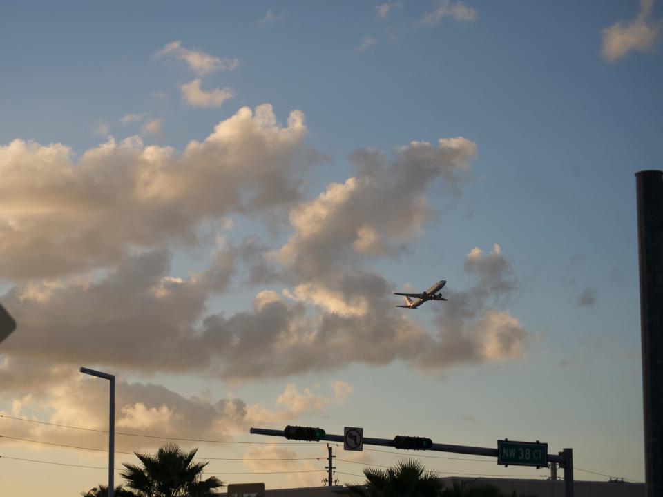 A plane takes off from Miami at sunset.