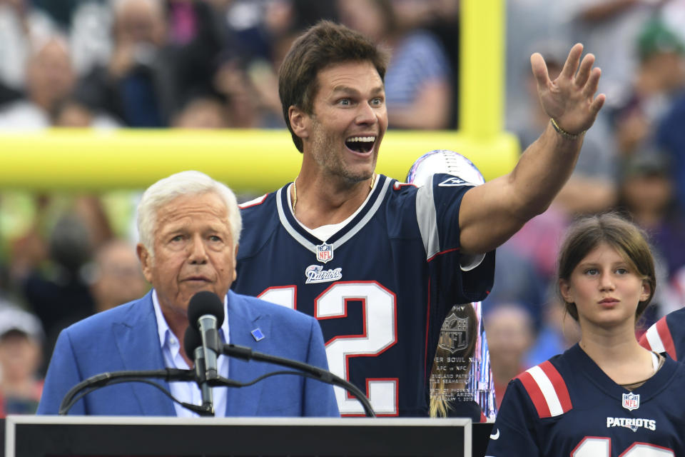 Former New England Patriots quarterback Tom Brady waves as Patriots owner Robert Kraft, left, addresses the crowd and Brady's daughter Vivian, right, looks on during a halftime ceremony held to honor Brady at the NFL football game between the Philadelphia Eagles and the Patriots, Sunday, Sept. 10, 2023, in Foxborough, Mass. (AP Photo/Mark Stockwell)