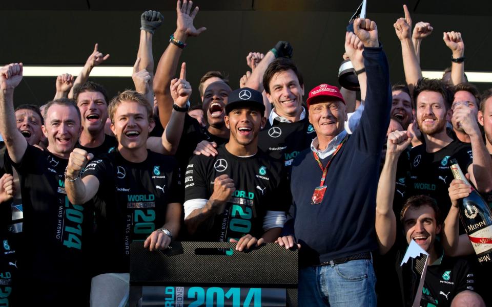  In this Sunday, Oct. 12, 2014 file photo Mercedes team drivers Lewis Hamilton of Britain, right, winner of the race, flanked by his teammate second place Nico Rosberg of Germany and Mercedes non-Executive Chairman former F1 driver Niki Lauda celebrate with all team members after the Formula One Russian Grand Prix at the 'Sochi Autodrom' Formula One circuit, in Sochi, Russia. Three-time Formula One world champion Niki Lauda, who won two of his titles after a horrific crash that left him with serious burns and went on to become a prominent figure in the aviation industry, has died. He was 70 - Pavel Golovkin /AP