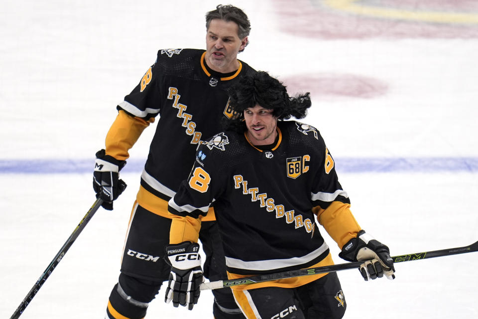 Former Pittsburgh Penguins player Jaromir Jagr, rear, skates in warm ups with Penguins captain Sidney Crosby after having his number retired during a pregame ceremony before an NHL hockey game between the Los Angeles Kings and Pittsburgh Penguins in Pittsburgh, Sunday, Feb. 18, 2024. (AP Photo/Gene Puskar)