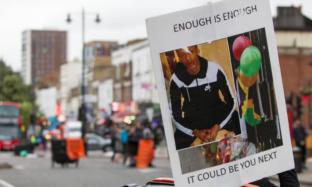 A banner showing Rashan Charles at a protest against his death.