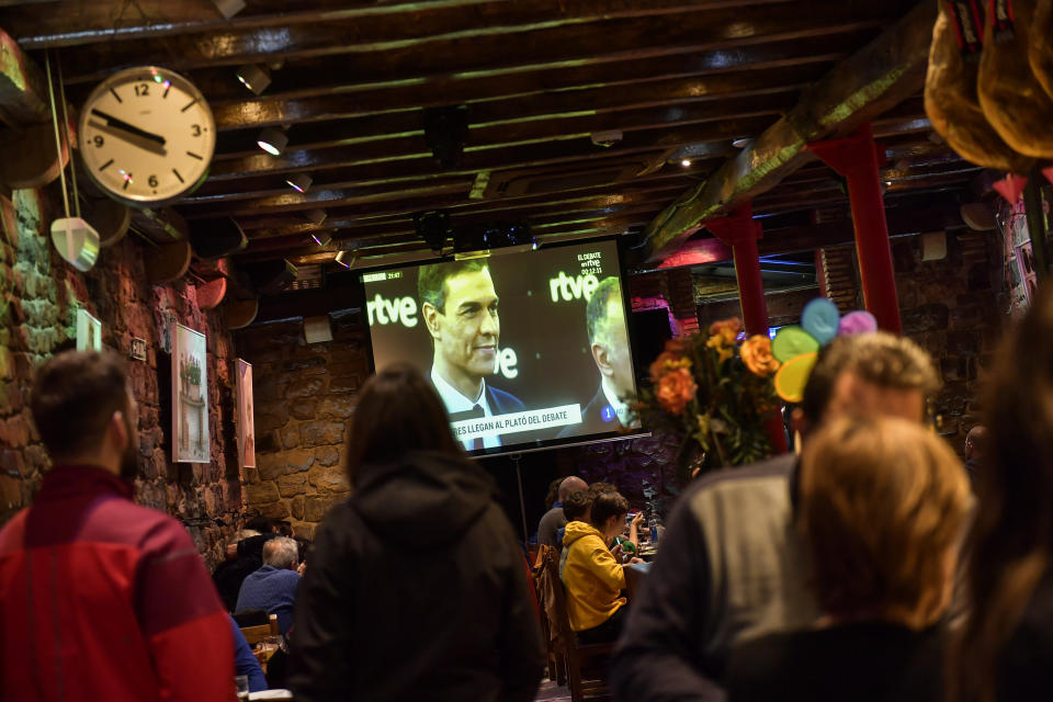 People watch a live televised general election debate between four main candidates, as one of them, Spain acting Primer Minister Pedro Sanchez of Socialist Party, smiles, in Pamplona, Spain, Monday April 22, 2019. The debate is the first of two televised debates after Spain's electoral board barred the far-right Vox party from participating because it has no presence in the country's parliament. Spain goes to the polls next April 28. (AP Photo/Alvaro Barrientos)