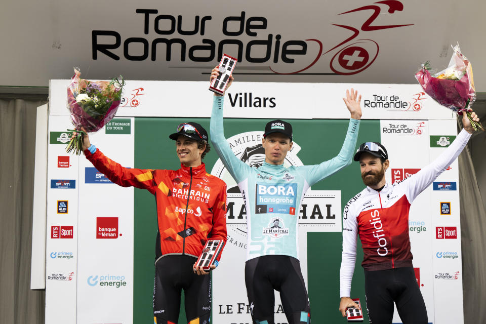 From left, second placed Gino Maeder from Switzerland, winner Aleksandr Vlasov from Russia and third placed Simon Geschke from Germany of team Cofidis, pose on the podium after the 75th Tour de Romandie UCI ProTour cycling race in Villars, Switzerland, Sunday, May 1, 2022. (Jean-Christophe Bott/Keystone via AP)