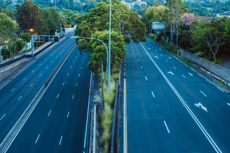 There are no cars on major city roads in Sydney during the corona virus pandemic as people stay at home in isolation. A street sign to the left reminds drivers to stay at home.