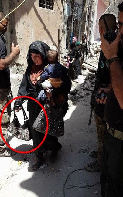 Woman holding detonator in Mosul blows herself up along with a small child moments after the picture was taken.  - Credit: Al-Mawsleya TV