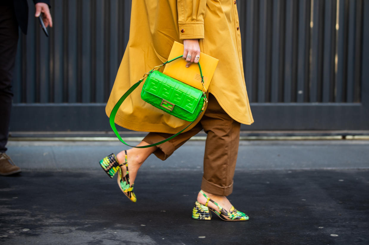 MILAN, ITALY - JANUARY 13: Estelle Pigault seen wearing yellow coat, yellow brown two tone overall, green Fendi bag and shoes with jungle print outside Fendi during Milan Fashion Week Fall/Winter 2020/2021 on January 13, 2020 in Milan, Italy. (Photo by Christian Vierig/Getty Images)