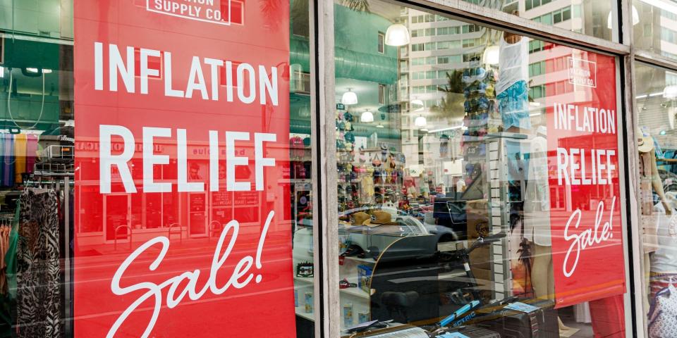 Signs in store windows note an inflation relief sale