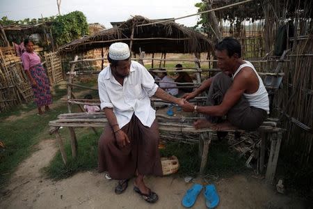 Men chat inside a Rohingya refugee camp outside Kyaukpyu in Rakhine state, Myanmar May 17, 2017. REUTERS/Soe Zeya Tun/Files