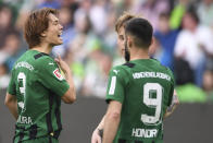 Mönchengladbach's Ko Itakura, left, celebrates scoring their side's first goal of the game during the German Bundesliga soccer match between Borussia Monchengladbach and Wolfsburg at the Volkswagen Arena in Wolfsburg, Germany, Sunday April 7, 2024. (Swen Pförtner/dpa via AP)