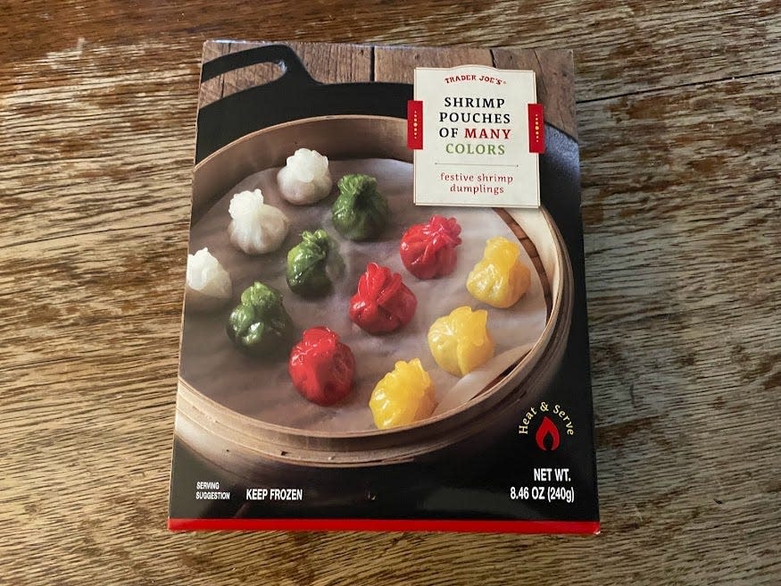 Box of Trader Joe's shrimp pouches of many colors with a picture of dumplings in a steamer on the box placed on a wooden counter